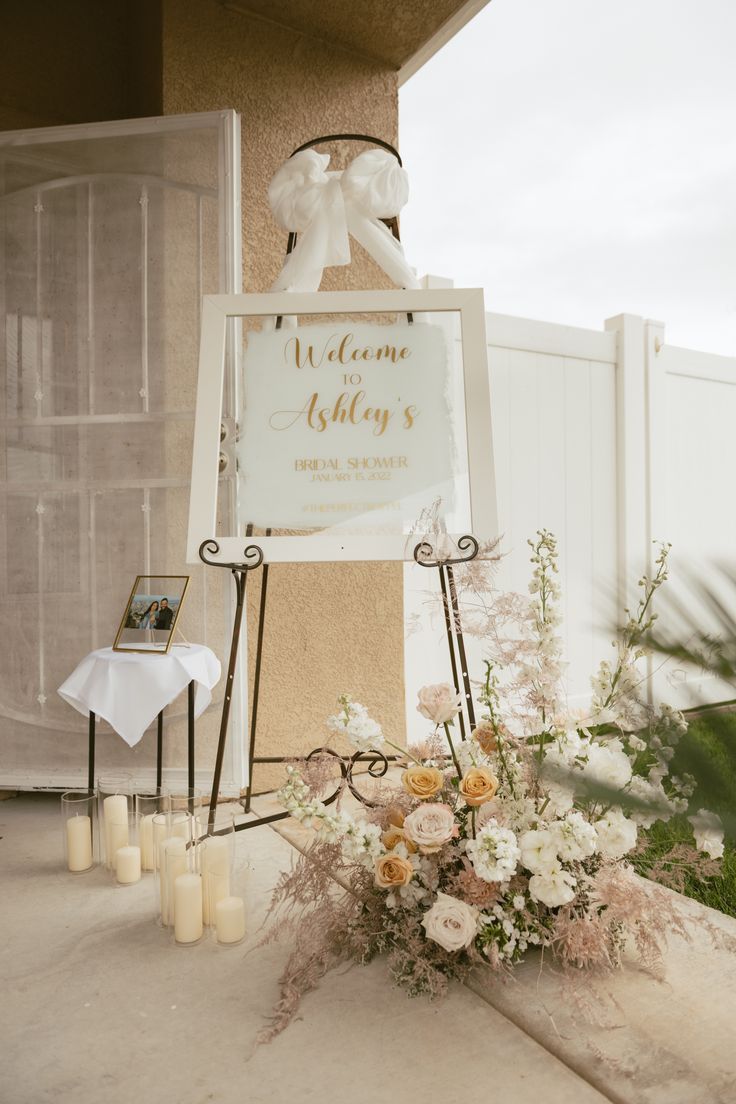 a welcome sign with flowers and candles in front of it