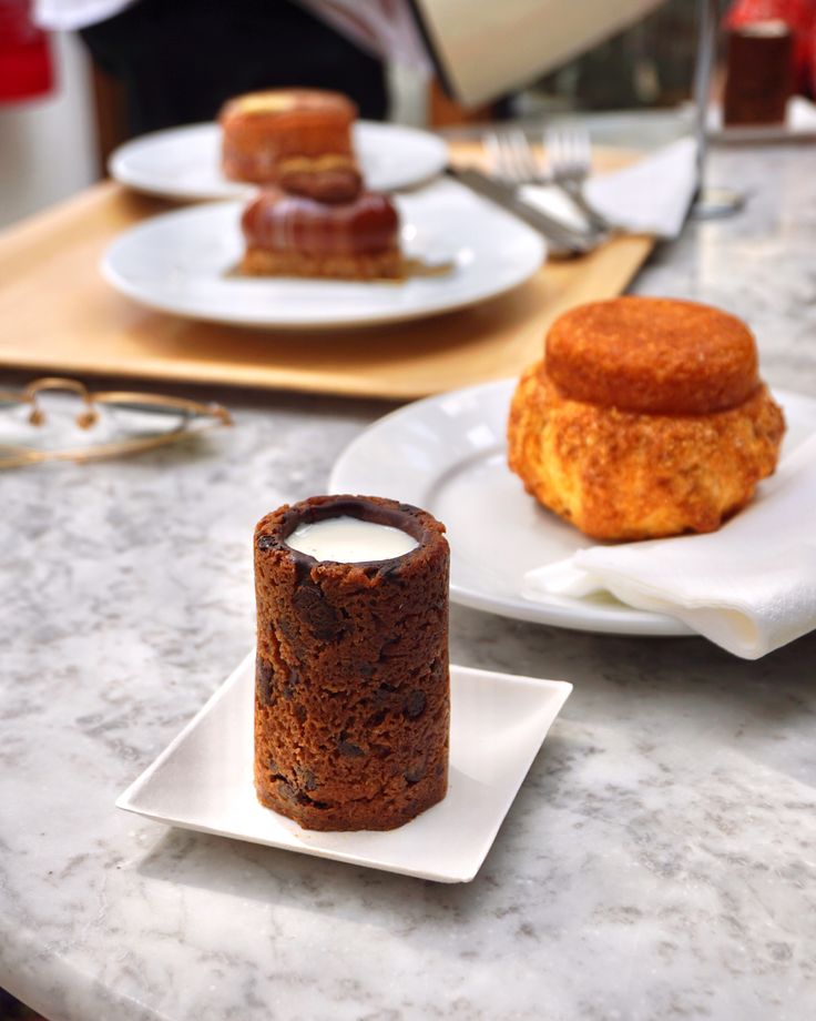 two desserts on plates sitting on a table