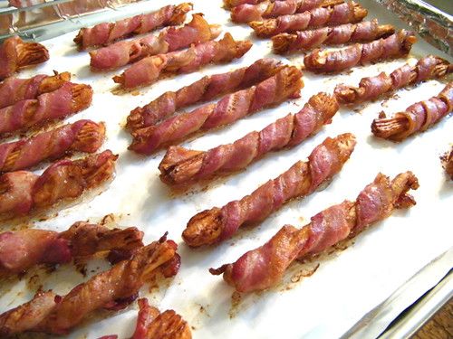 bacon is being cooked on a baking sheet