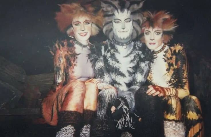 three people dressed in costumes sitting next to each other