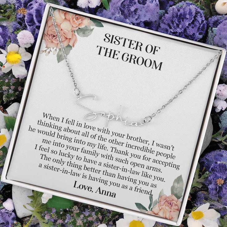 the sister of the groom necklace is displayed in front of flowers