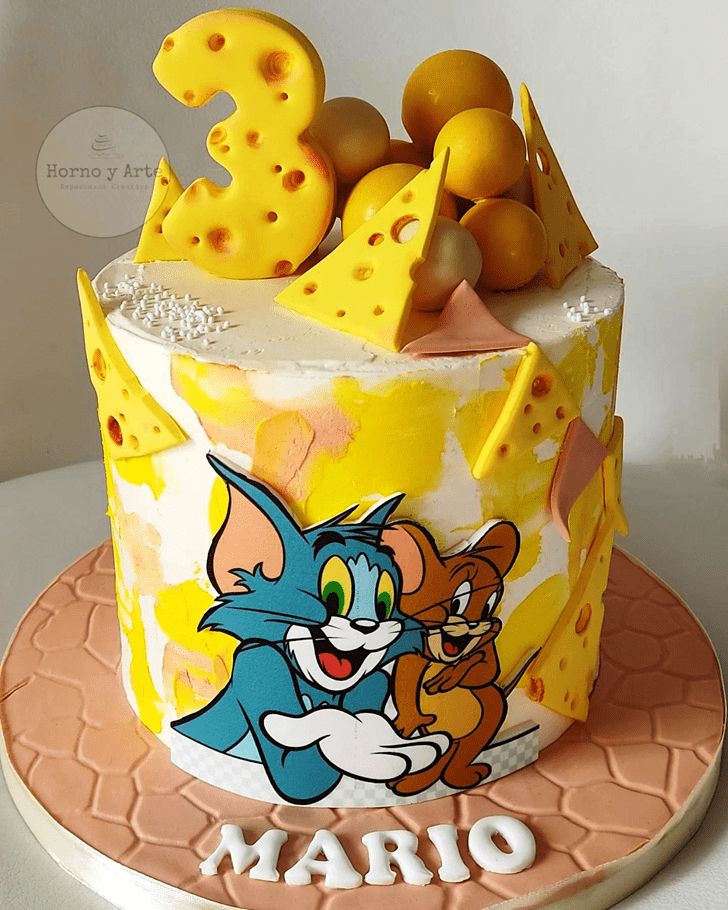 a birthday cake decorated with an image of tomy and jerry on the top tier