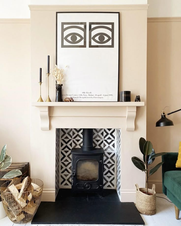 a living room with a fire place in the center and pictures on the wall above it