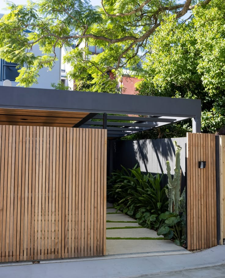 the entrance to a modern home with wood slats on the doors and side walls