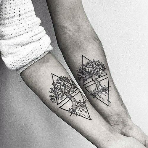 two people with matching tattoos on their arms, one has a tree and the other is a triangle