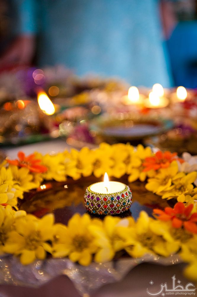 a lit candle sitting on top of a plate covered in flowers