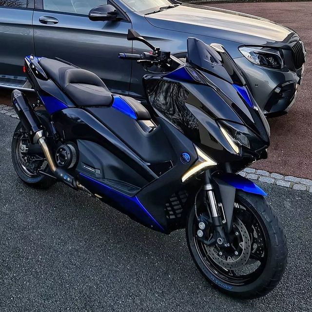 two motorcycles parked next to each other in front of a car