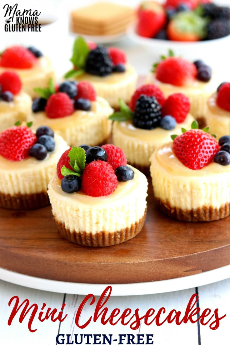 mini cheesecakes with fresh berries and blueberries are on a wooden platter