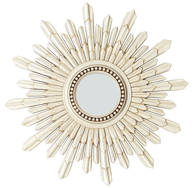 a mirror that is sitting on top of a white wall mounted shelf and has spikes in the shape of a sunburst