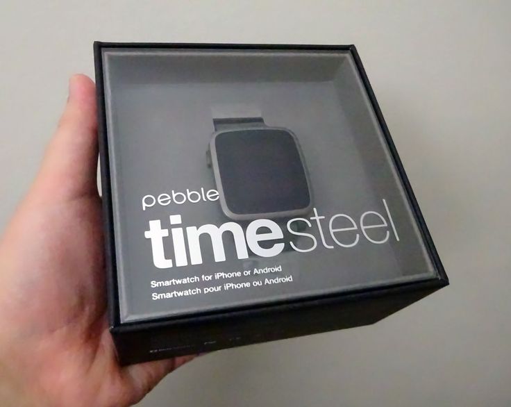 a person holding up an apple watch in a box