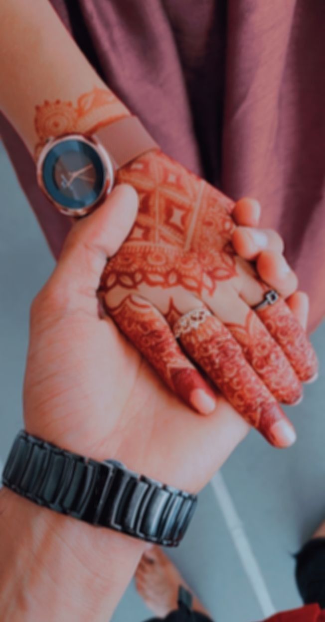 two people are holding their hands together with hendi tattoos on them and one is wearing a watch