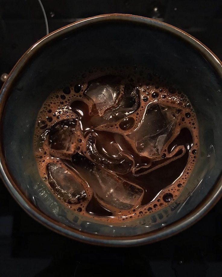 a metal bowl filled with liquid on top of a stove