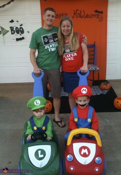 a man and two women standing next to children in toy cars with pumpkins on them