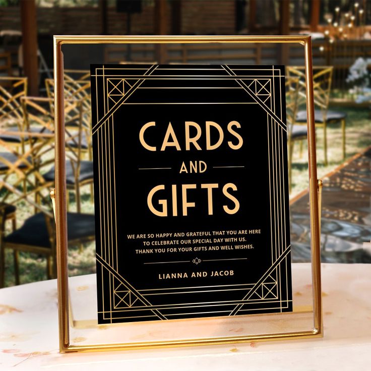 a black and gold card and gifts sign sitting on top of a table