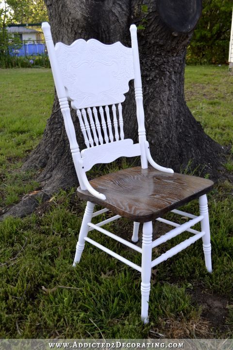 an old white rocking chair sitting under a tree