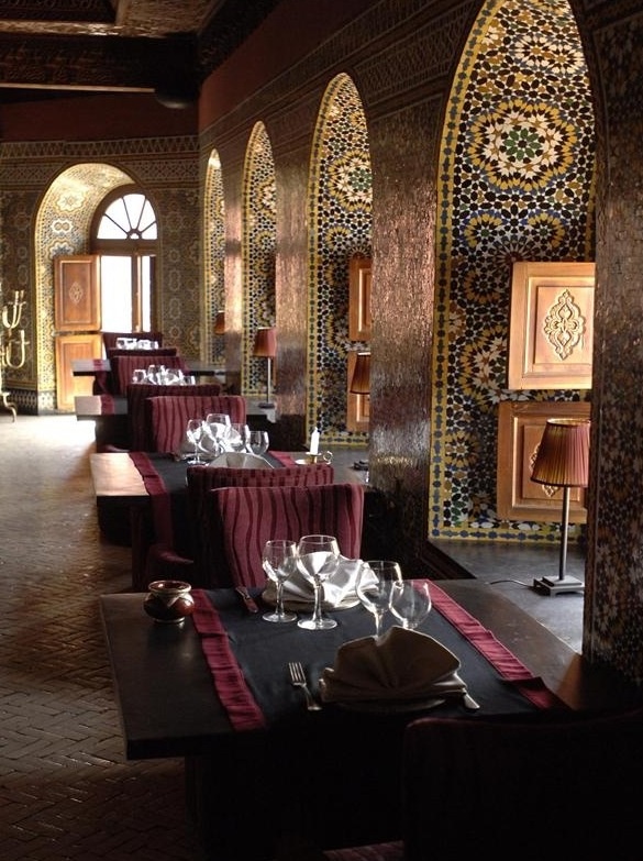 a restaurant with tables and chairs covered in red tablecloths, plates and silverware