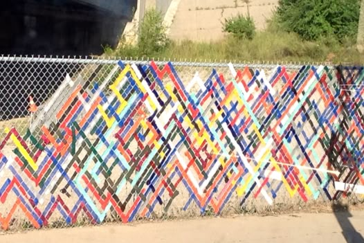 a fence made out of strips of colored paper