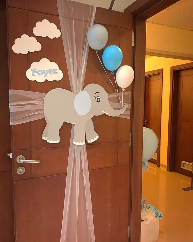 an elephant door decoration with balloons on the front and back doors for baby's first birthday