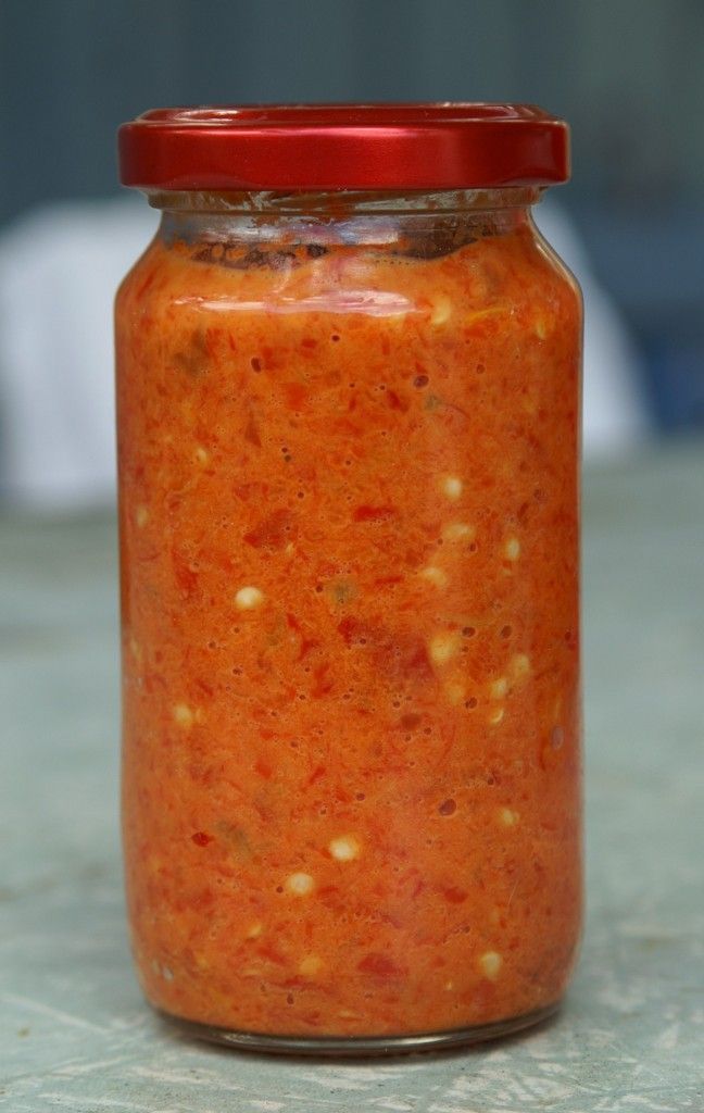 a jar filled with red sauce sitting on top of a counter