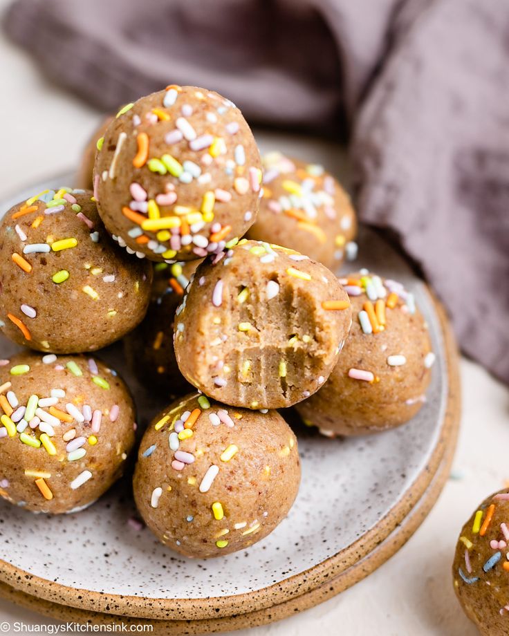 a plate filled with chocolate donuts covered in sprinkles