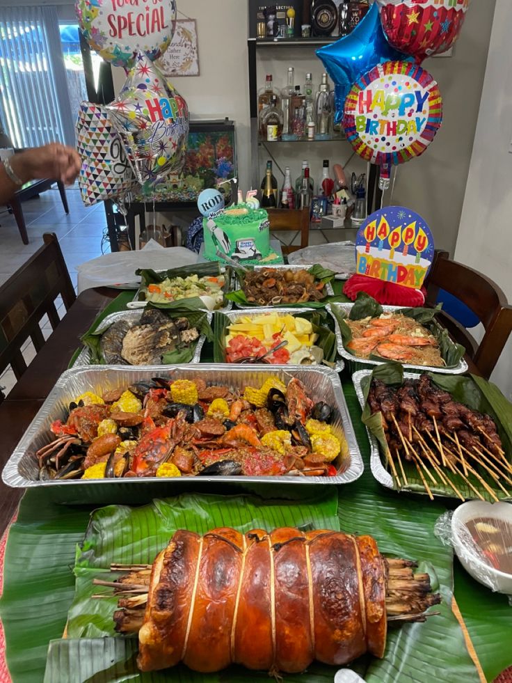 a table filled with lots of food and balloons