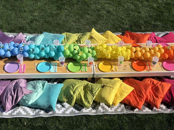 there are many different colored items on the table and in the background is a picnic blanket