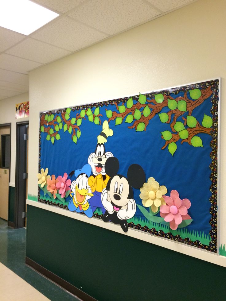 this is an image of a mickey mouse bulletin board on the wall in a school hallway