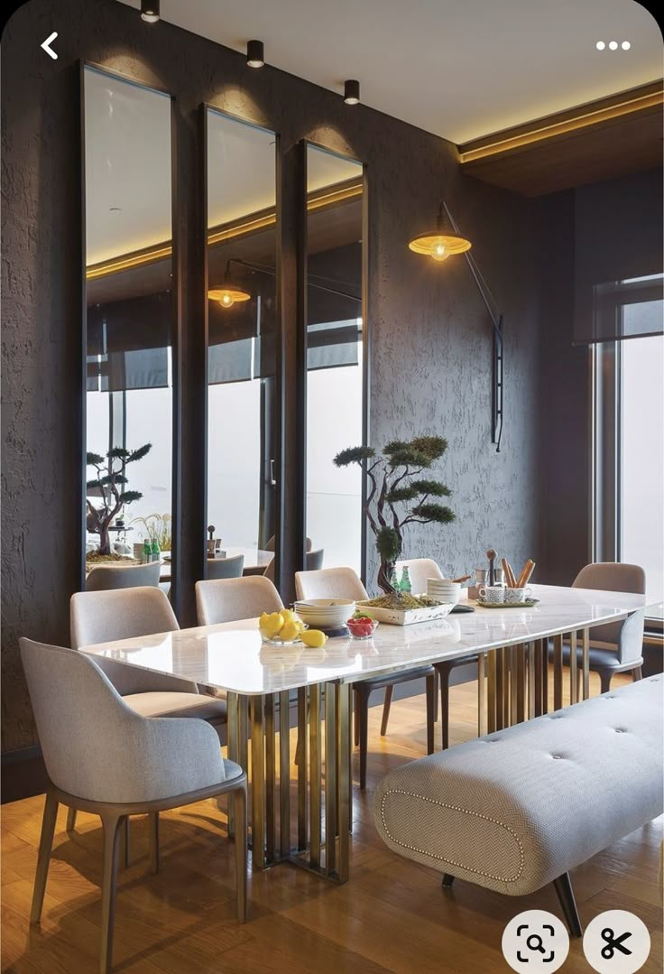 a dining room table and chairs with mirrors on the wall