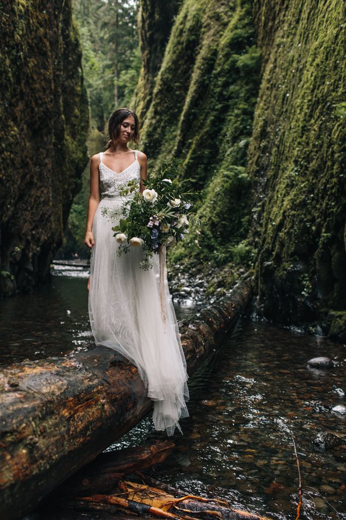 a woman in a white dress is walking through the water