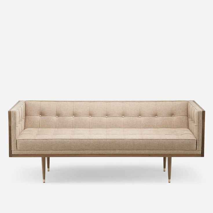 a beige couch sitting on top of a wooden frame