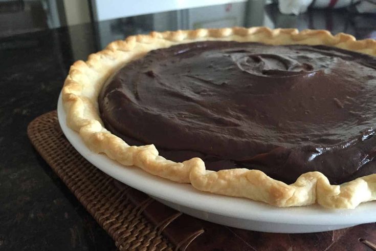 a chocolate pie sitting on top of a white plate