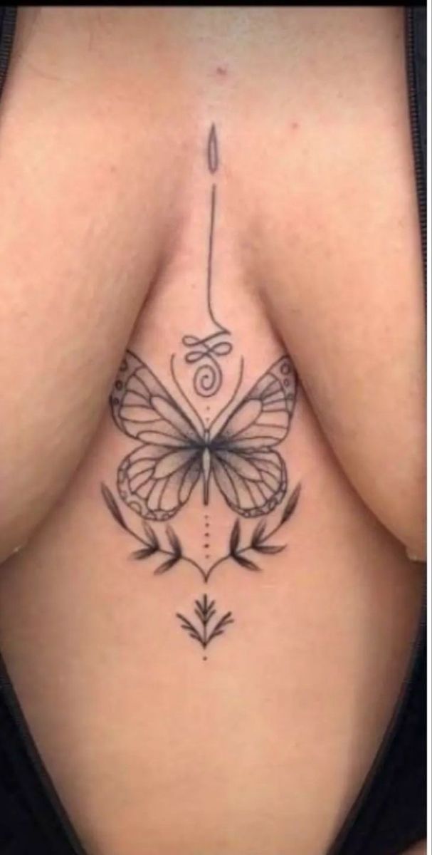 a woman's breast with a butterfly tattoo on her chest and an arrow in the middle