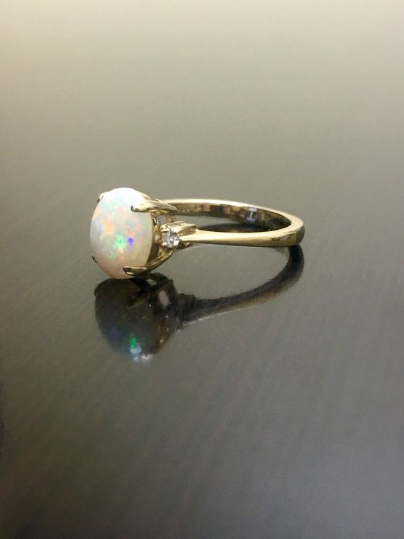 an opal and diamond ring sits on a table