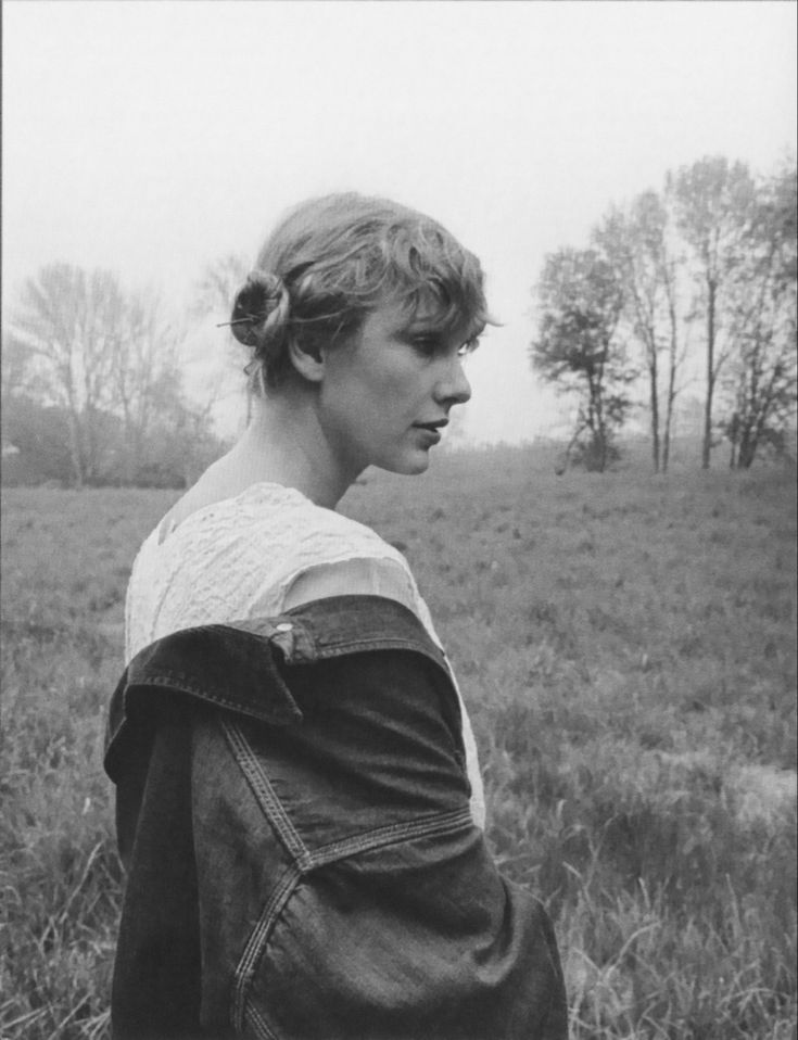 a black and white photo of a woman in a field