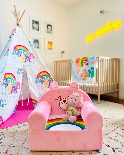 a child's room with a teepee tent, teddy bear and rainbow rug