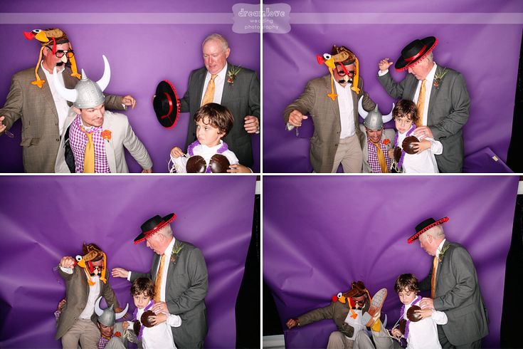 a group of people standing next to each other in front of a purple wall with hats on