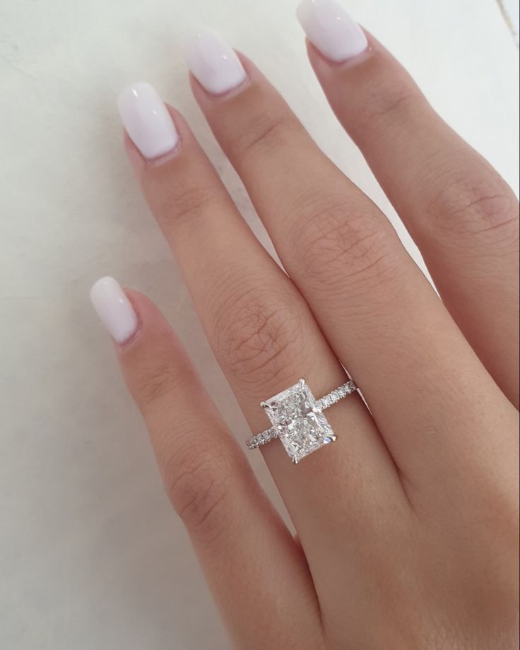 a woman's hand with a diamond ring on it