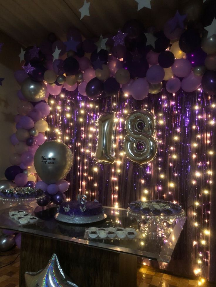 a birthday party with balloons and streamers in the shape of number eight on display