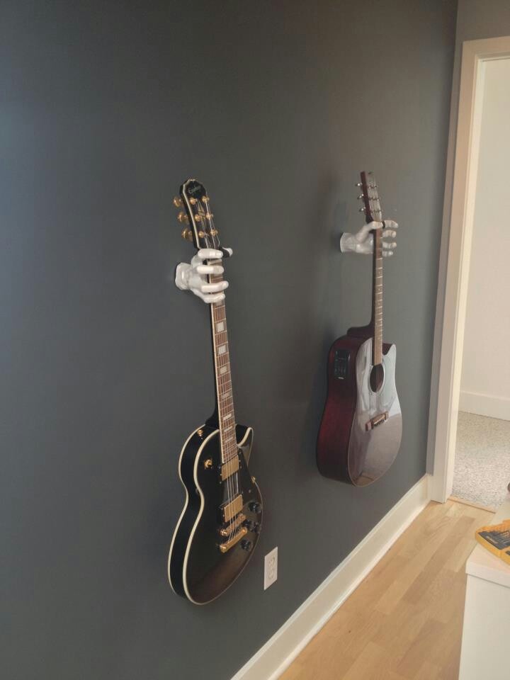 two guitars are hanging on the wall next to each other