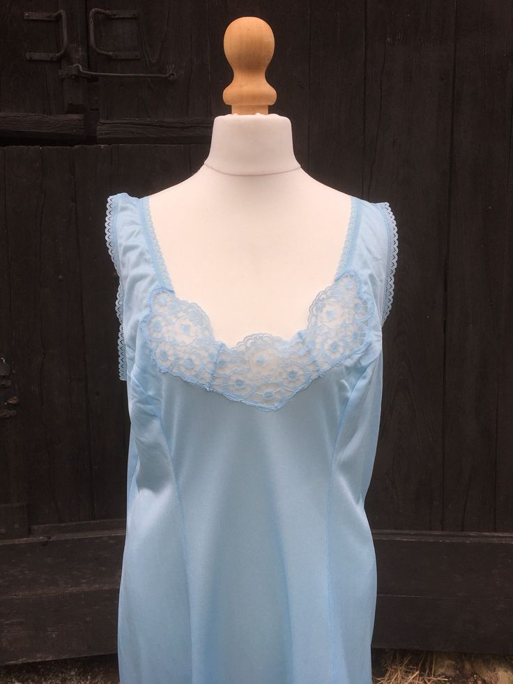 Indulge in the allure of vintage lingerie with this stunning Vintage Blue Lace Slip Dress, proudly made in France. Crafted with meticulous attention to detail, this delicate piece evokes a sense of elegance and timeless beauty. The dress features intricate lace detailing on the bodice and hemline, adding a touch of femininity and charm. The beautiful blue color enhances its allure, making it a truly captivating garment. Whether worn as intimate lingerie or as an enchanting nightwear piece, this Blue Lace Fitted Camisole, Blue Fitted Lace Camisole, Fitted Blue Lace Camisole, Fitted Sleeveless Nightgown With Delicate Lace, Blue Sheer Fitted Sleepwear, Blue Fitted Sheer Sleepwear, Fitted Sheer Blue Sleepwear, Fitted Blue Sheer Sleepwear, Vintage Blue Wedding Nightgown