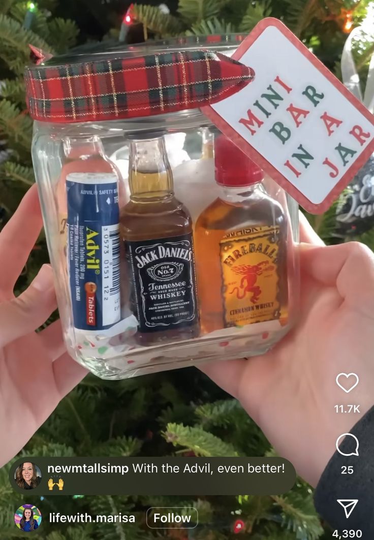 someone is holding up a christmas ornament in front of a tree with some bottles