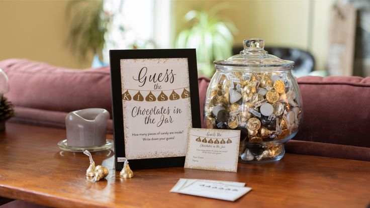 a wooden table topped with a glass jar filled with lots of gold and silver coins