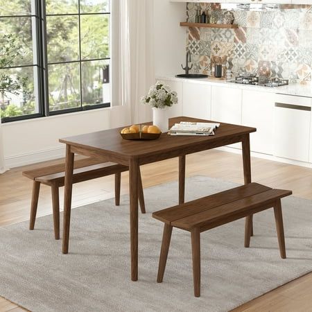 a wooden table with two benches in front of it and an area rug on the floor