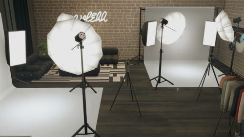 an empty room with several lighting equipment in front of a brick wall and flooring