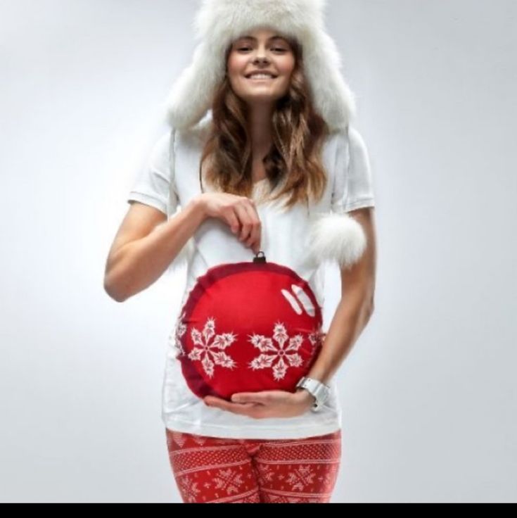 a woman in red and white is holding a hat