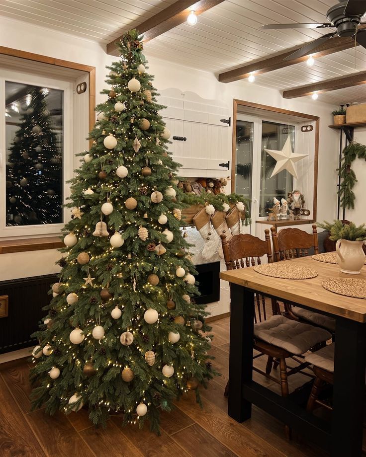 a decorated christmas tree in the middle of a dining room