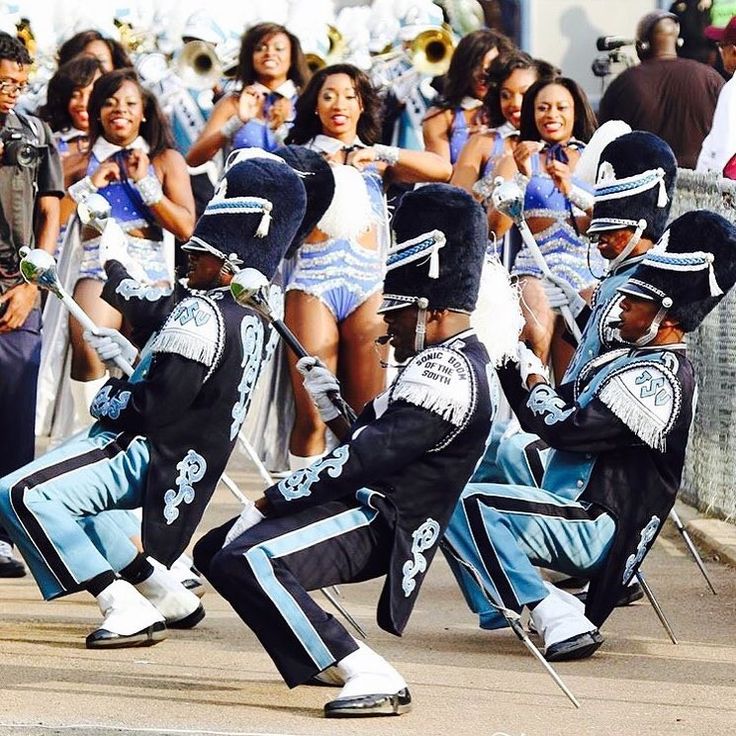 a group of people that are standing in the street with marching equipment on their feet