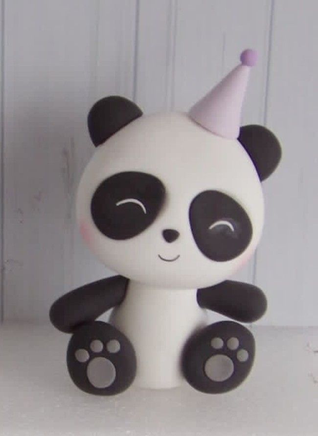 a white and black panda bear with a party hat