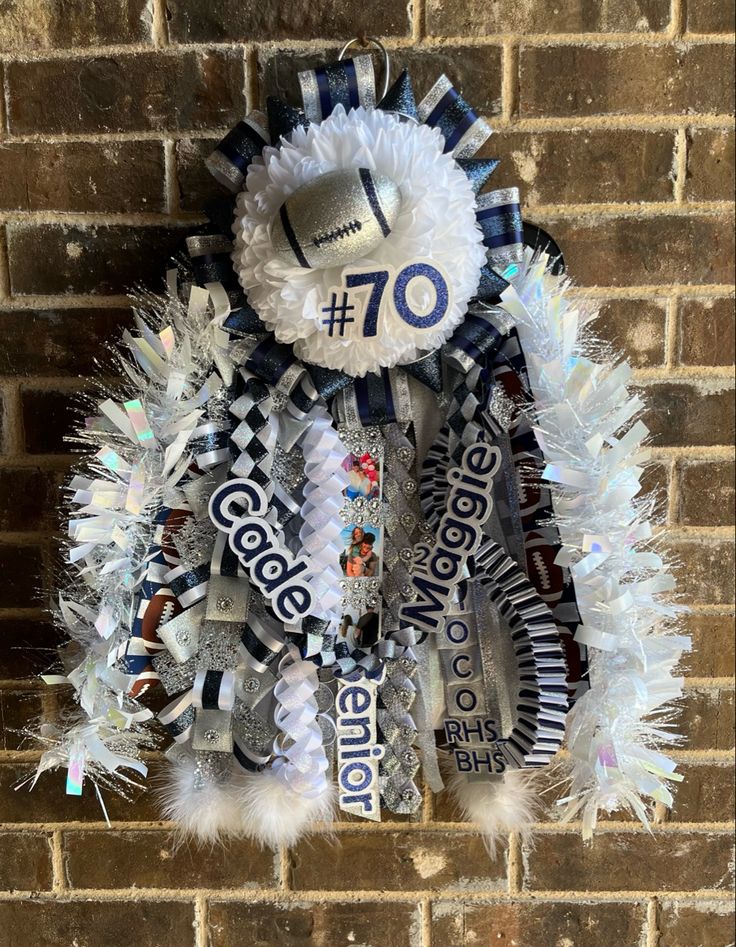 a football fan's name and number on a wreath hanging from a brick wall