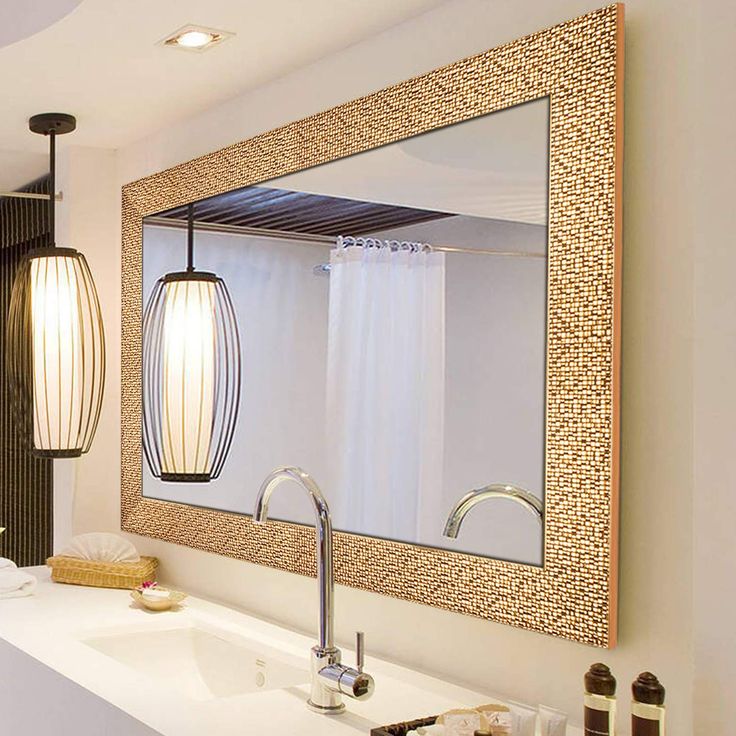 a bathroom with a sink, mirror and hanging light fixture in it's center